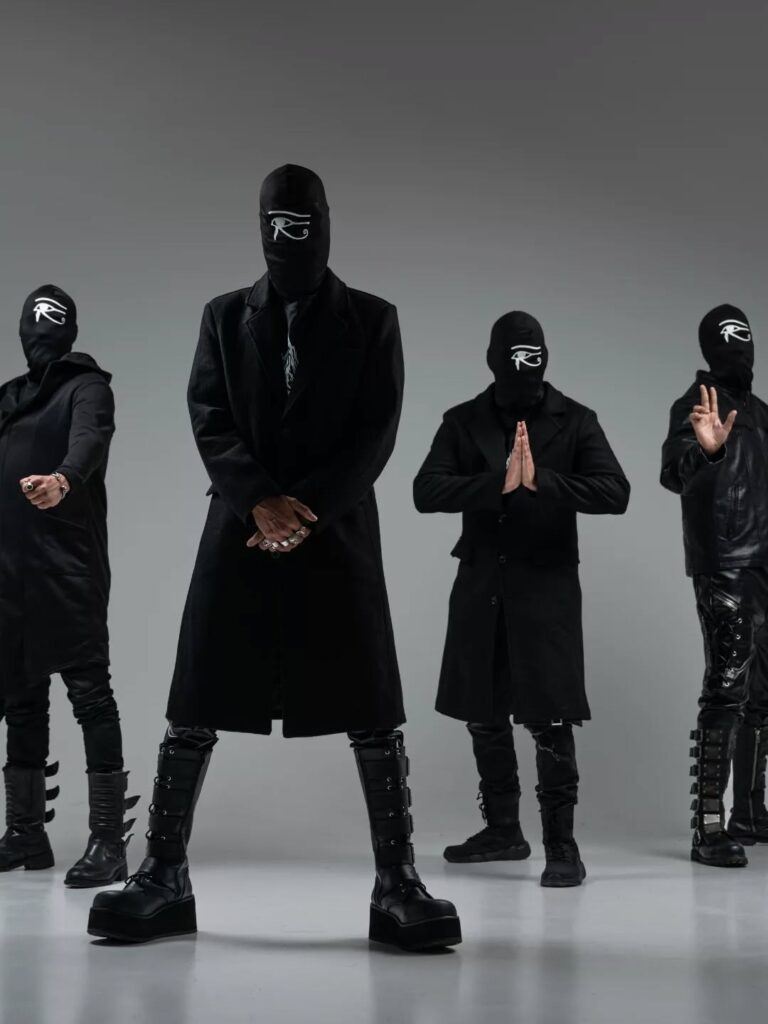 Muzycy dominikańskiego zespołu Rupes Nigra w maskach z symbolem oka Horusa