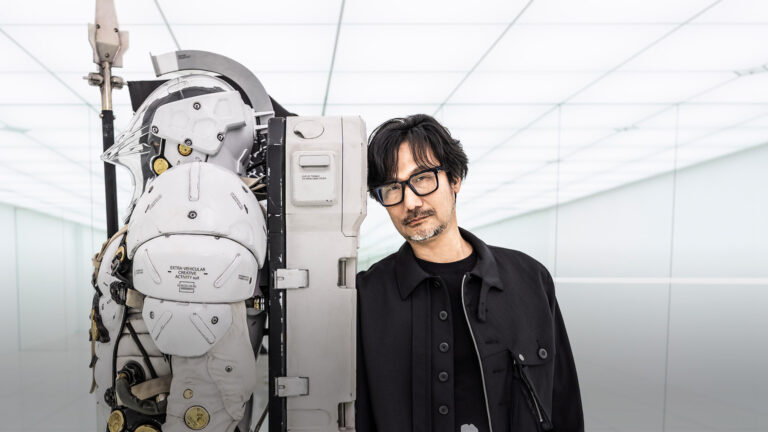 Hideo Kojima w siedzibie Kojima Productions obok statuy maskotki Homo Ludens